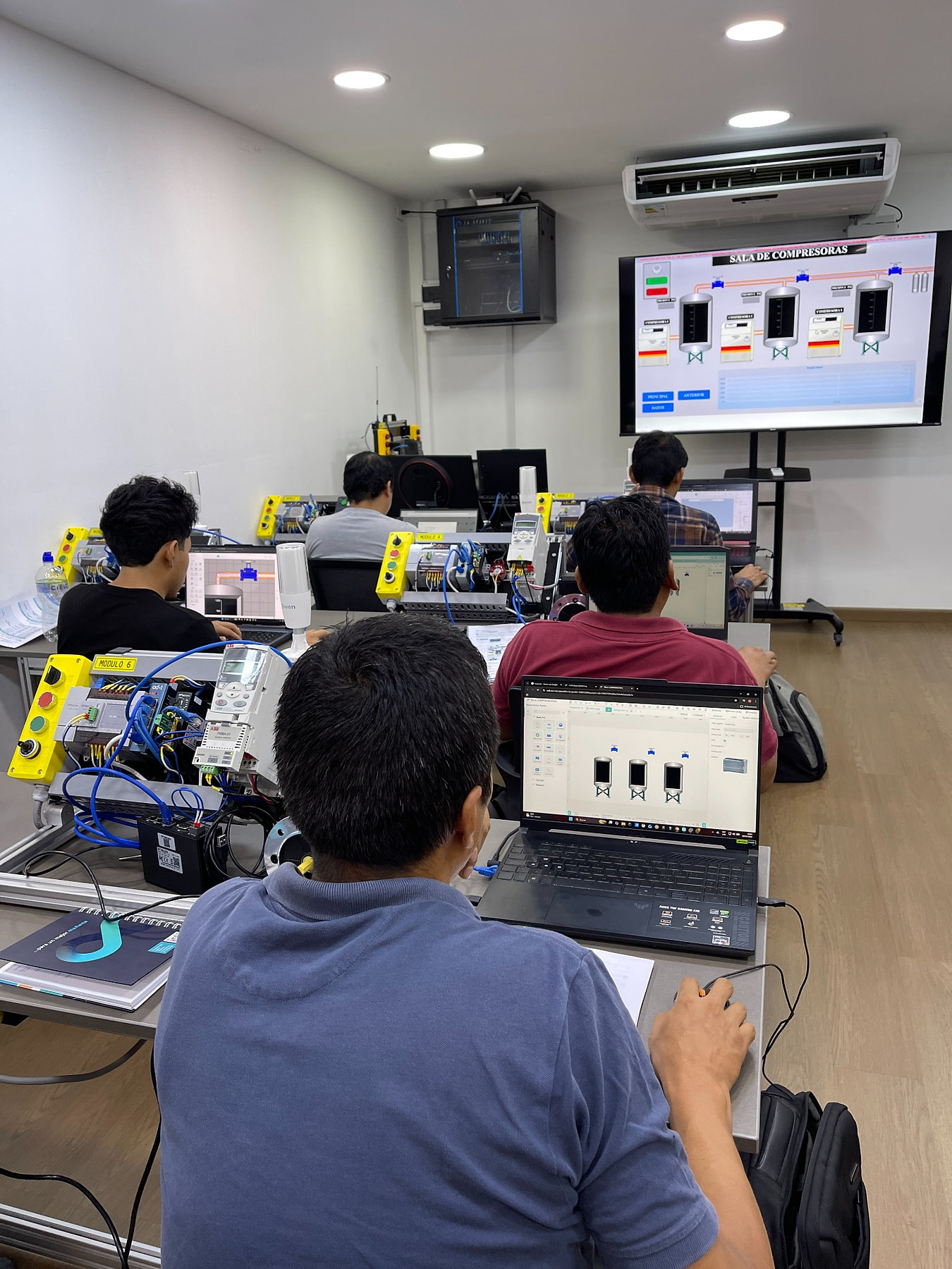 Participantes trabajando en sus computadoras y módulos